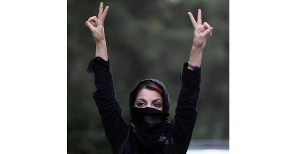 An Iranian woman holds her hands in the air and makes V signs as she protests in the streets on July 9, 2009 in Tehran - Source: Getty Images.